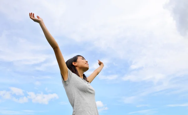 Aziatische vrouw hand omhoog met blauwe hemelachtergrond — Stockfoto