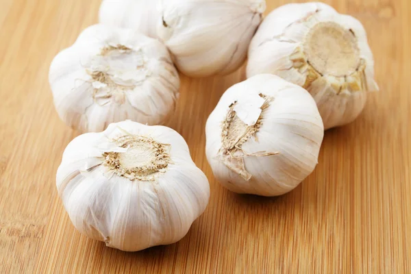 Garlic on wooden plank — Stock Photo, Image