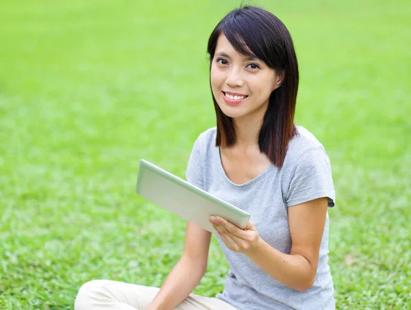 Asiatisk kvinna på gräs med tablett — Stockfoto