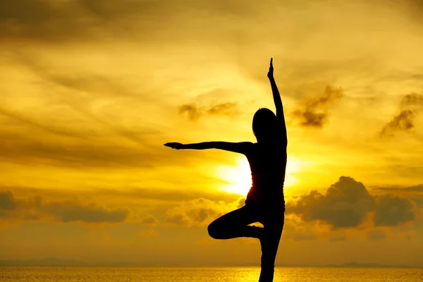Жінка робить йогу під час заходу сонця — стокове фото