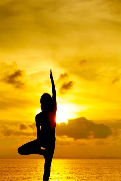 Žena dělá jógu v době západu slunce — Stock fotografie