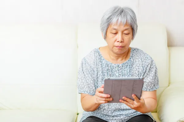 Aziatische oude vrouw met behulp van digitale Tablet PC — Stockfoto