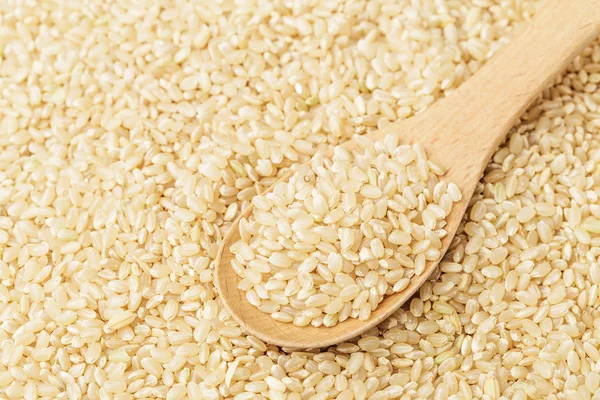 Brauner Reis auf hölzernen Teelöffel — Stockfoto