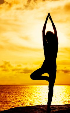 gün batımı sırasında yoga yaparken kadın