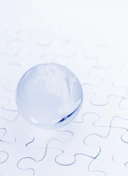 Crystal glass globe ball on puzzle — Stock Photo, Image