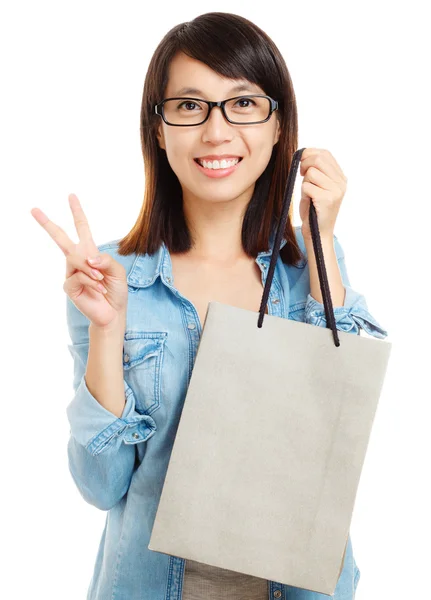 Mulher asiática segurando saco de compras com sinal de vitória — Fotografia de Stock