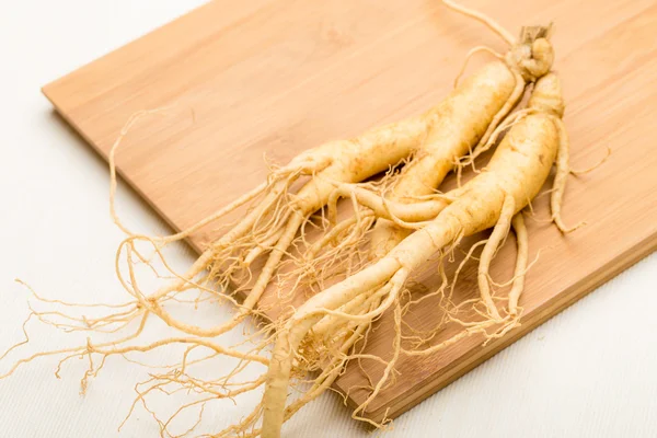 Fresh ginseng stick on the wooden plank — Stock Photo, Image