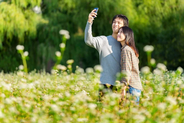 Asian couple take photo by mobile phone — Stock Photo, Image