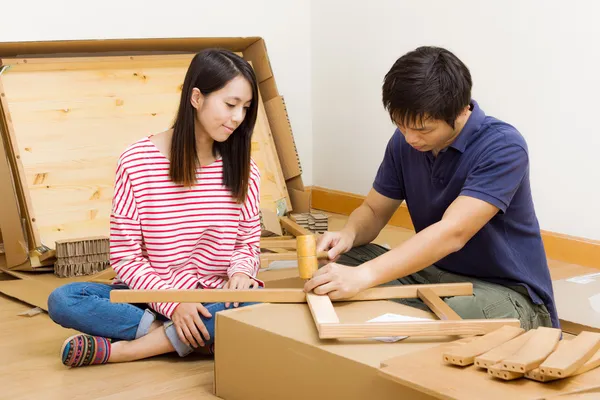 Asiatiska par montering nya möbler — Stockfoto