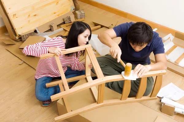 Asiático pareja montaje nuevo silla — Foto de Stock