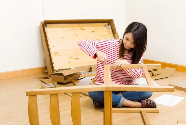 Mujer asiática usando controlador de esparcimiento para ensamblar muebles — Foto de Stock
