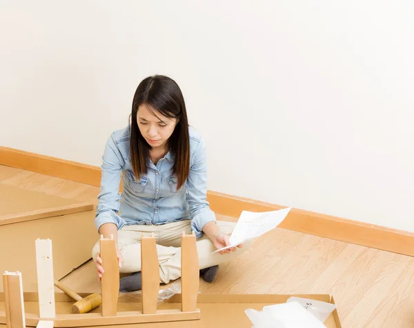 Asian woman assembling chair by hammer with instruction — Stock Photo, Image