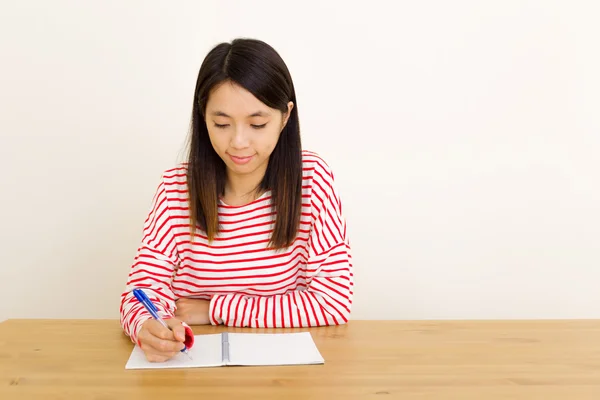 Азиатка пишет на блокноте — стоковое фото