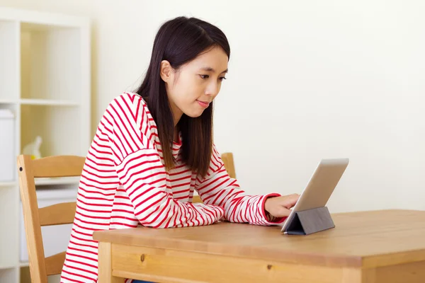Азиатка смотрит на планшет — стоковое фото
