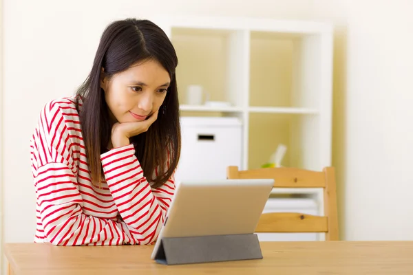 Asian woman watching movie through computer tablet — Zdjęcie stockowe