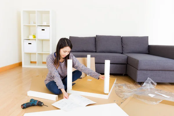 Asian woman assembling new furniture — Stock Photo, Image