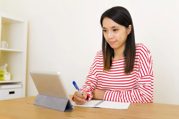 Азиатская женщина учится через цифровой планшет Стоковое Изображение