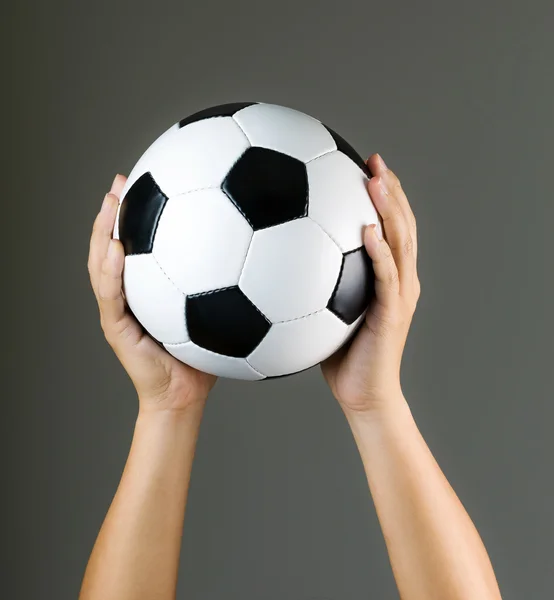 Mão segurando bola de futebol — Fotografia de Stock