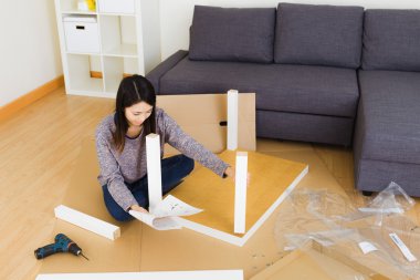 Woman assembling furniture clipart