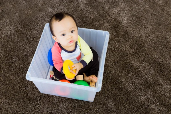 Plastik kutu içinde oynayan bir Asya bebek — Stok fotoğraf