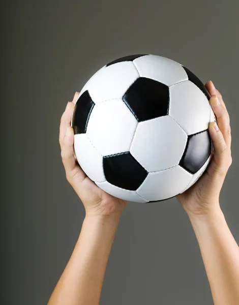 Manos sosteniendo pelota de fútbol — Foto de Stock