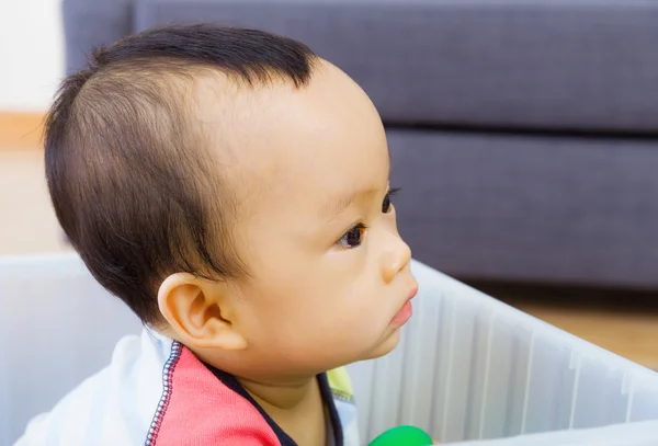 Kleine baby kijkend naar een kant — Stockfoto