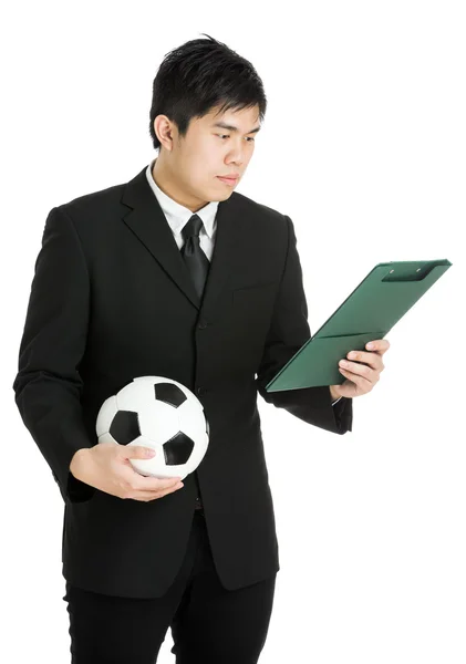 Empresario mirando lima y sosteniendo pelota de fútbol — Foto de Stock