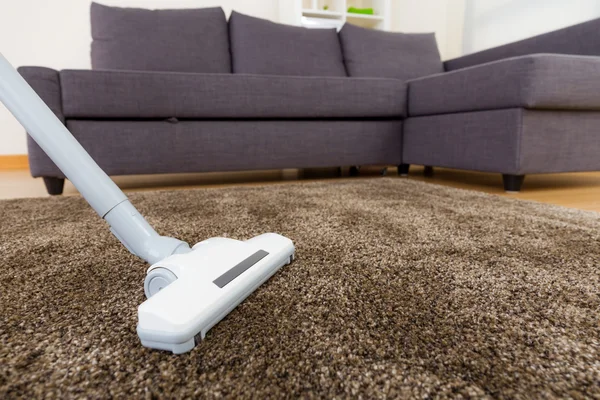 用真空吸尘器在客厅地毯 — 图库照片