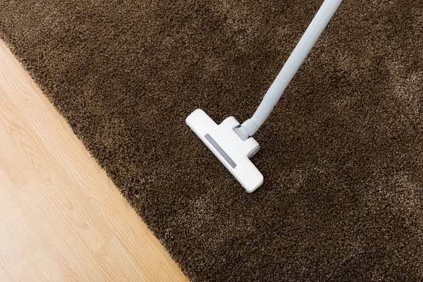 Karpet cokelat dengan vacuum cleaner di ruang tamu — Stok Foto