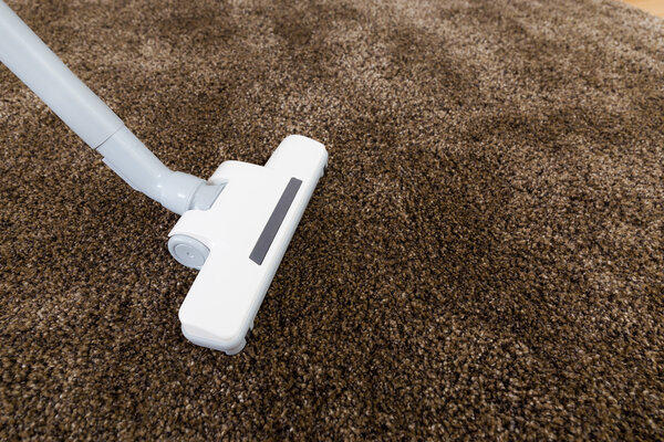 Brown carpet with vacuum cleaner in living room