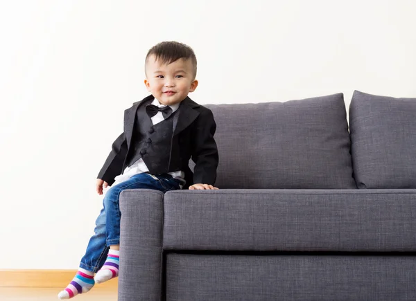 Beetje kid zitplaatsen op sofa — Stockfoto