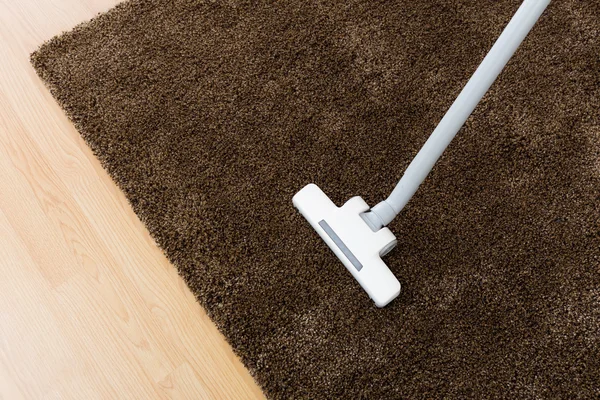 Head of modern vacuum cleaner on carpet — Stock Photo, Image