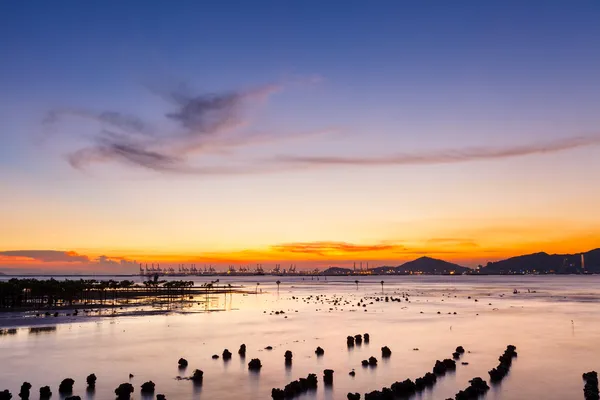 Sunset over sandy beach in low tide — Stock Photo, Image