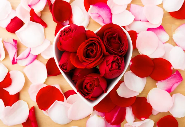 Red rose inside the heart shape bowl with petal beside — Stock Photo, Image