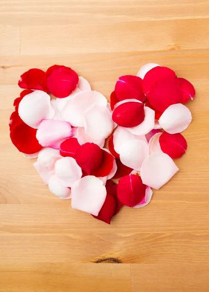 Лепестки роз формируют форму сердца — стоковое фото