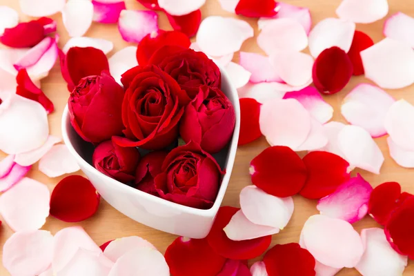 Beautiful Red rose inside heart shape bowl with petal beside — Stock Photo, Image