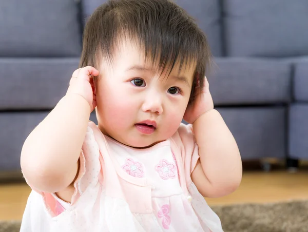 Little girl using hand to cover ear — Stock Photo, Image