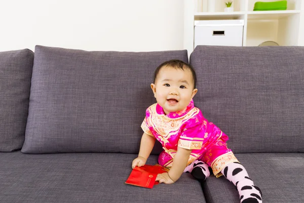 Asiático bebê segurando bolso vermelho com roupas chinesas tradicionais — Fotografia de Stock