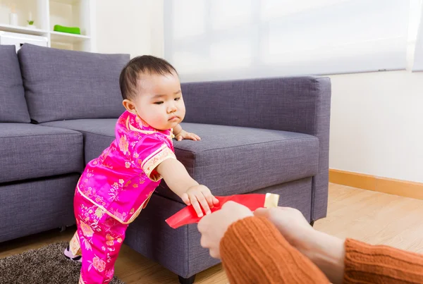 Bebé chino tomando bolsillo rojo de adulto —  Fotos de Stock