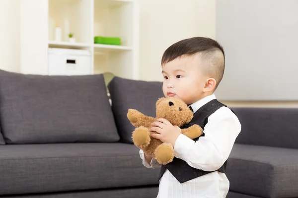 Маленький мальчик играет в куклу дома — стоковое фото