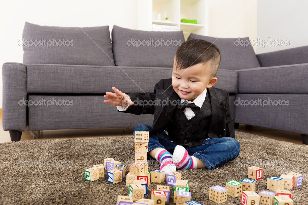Little boy playing toy block at home