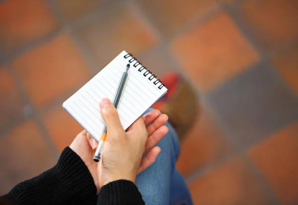 Main de femme avec bloc-notes et stylo — Photo