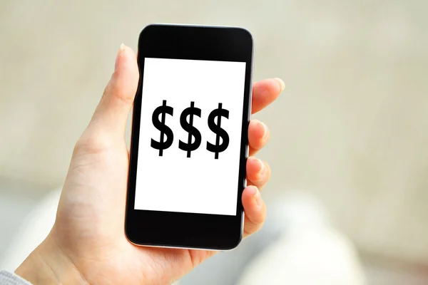 Рука людини тримає мобільний телефон зі знаком долара на екрані — стокове фото