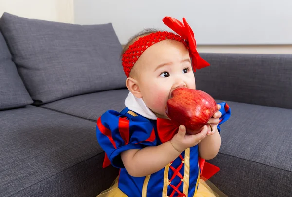 Dítě jíst jablko s Halloweenskou párty oblékání — Stock fotografie