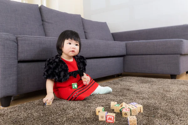 Klein meisje spelen speelgoed blok thuis — Stockfoto