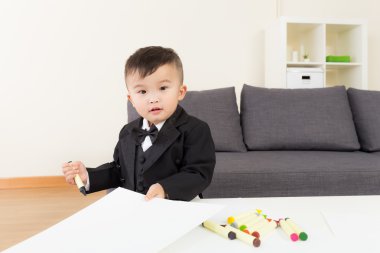 Asyalı bebek evde resim çiziyor.