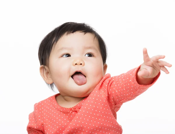 Asian baby gilr showing tongue and hand pointing front — Stock Photo, Image