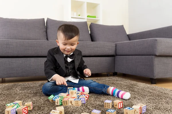 Menino jogar bloco de brinquedo de madeira em casa — Fotografia de Stock