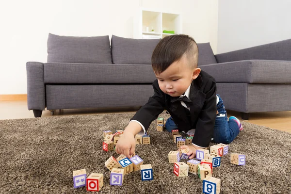 Pieni poika pelata lelu lohko kotona — kuvapankkivalokuva