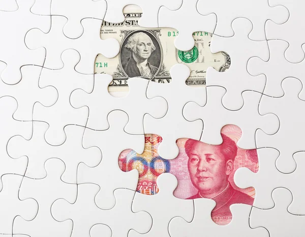 White puzzle with Chinese yuan and US dollar banknote — Stock Photo, Image